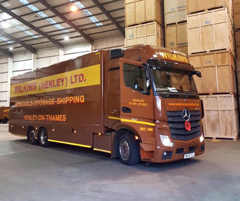 A Wilkins Removals lorry inside a warehouse.