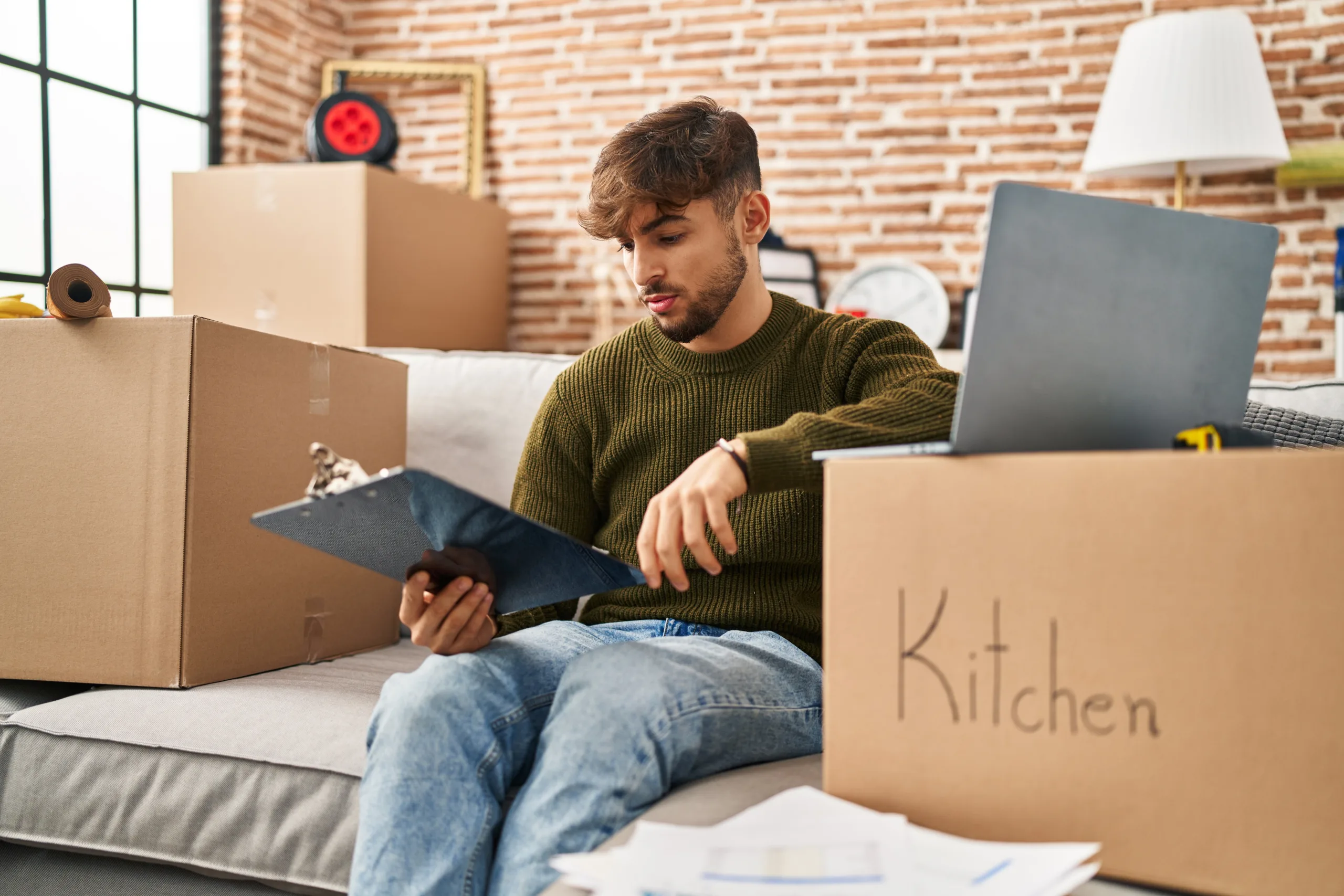 man using laptop and checklist to get ready for reading removal